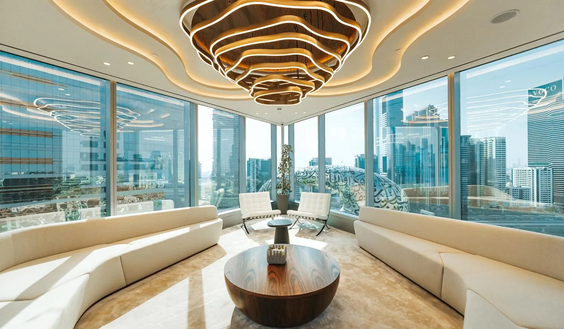 Executive lounge with sculpted ceiling lighting overlooking Dubai